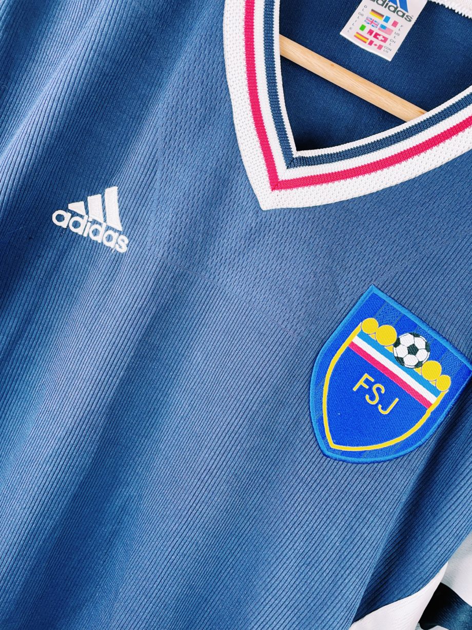 maillot vintage Adidas de la Yougoslavie, 1998/2000. Le maillot reprend les couleurs du drapeau de la République Fédérale de Yougoslavie : bleu, blanc et rouge, qu'on peut voir sur le joli col en V