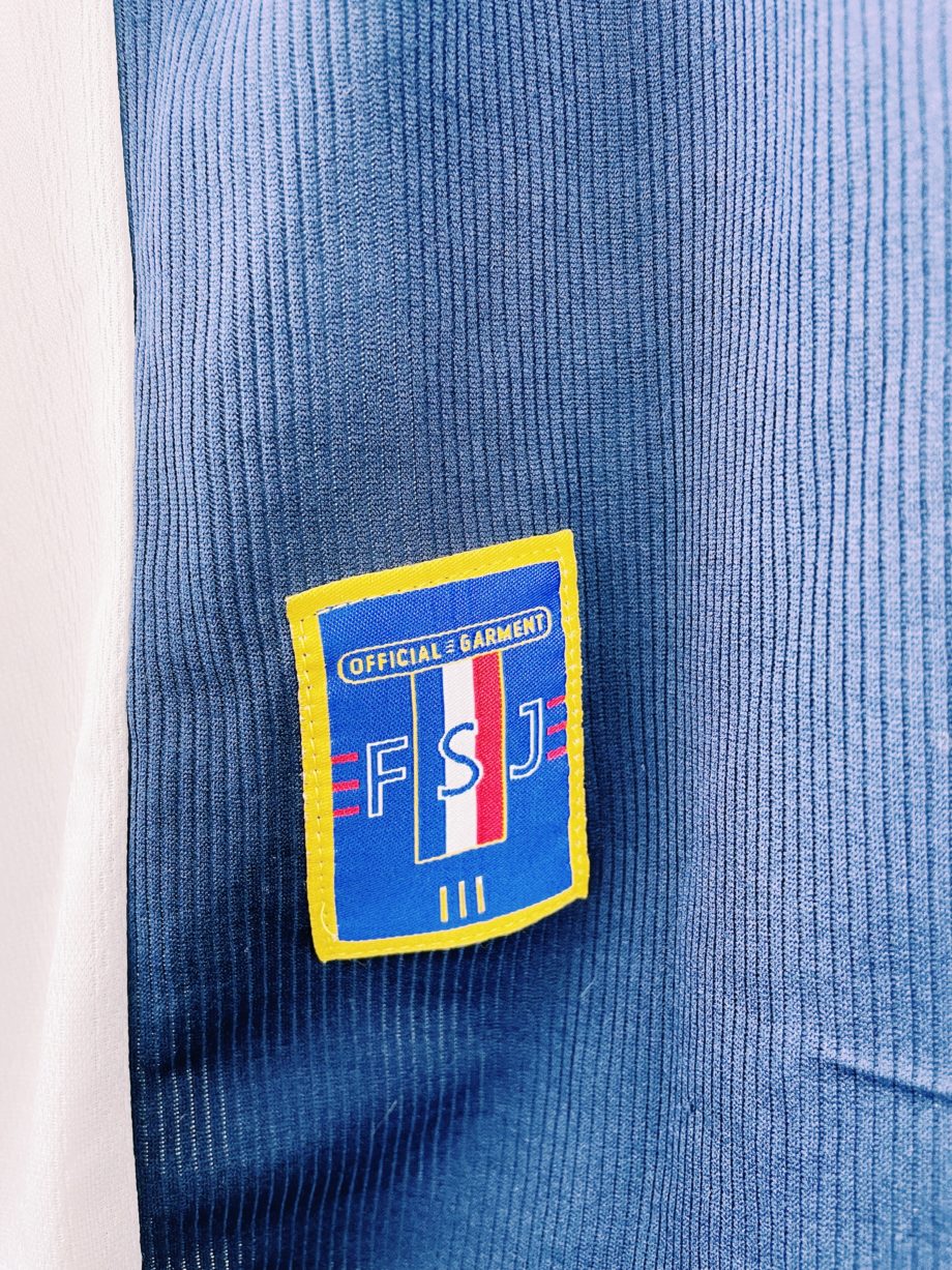 maillot vintage Adidas de la Yougoslavie, 1998/2000. Le maillot reprend les couleurs du drapeau de la République Fédérale de Yougoslavie : bleu, blanc et rouge, qu'on peut voir sur le joli col en V